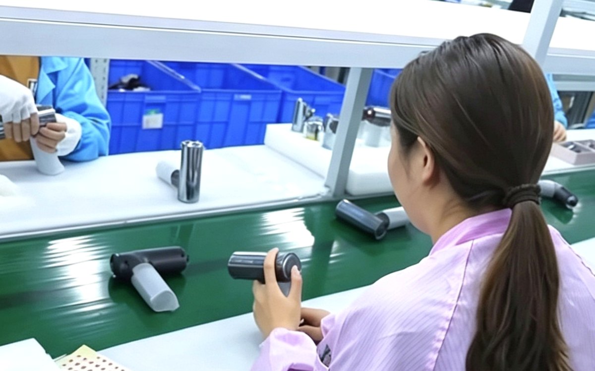 Worker assembling massage devices on the line